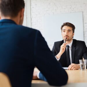 Attorney and client sitting across from tax examiner during IRS interview